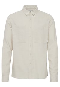 Helles beiges Langarmhemd aus strukturiertem Stoff, mit klassischem Kragen, Knopfverschluss und zwei Brusttaschen.