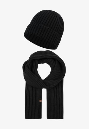 Schwarzes geripptes Strickschal- und Mützenset mit einem vertikalen Strukturmuster und einem dezenten Markenetikett am Schal. Weiches Material.