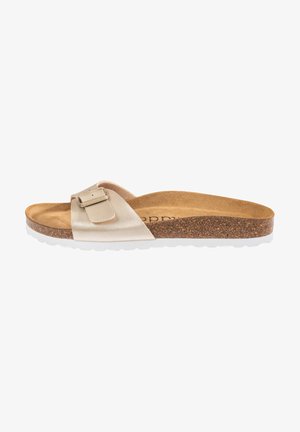 Sandale beige avec une boucle métallique, semelle en liège et semelle extérieure en caoutchouc blanc. Design plat avec une seule sangle sur le dessus.