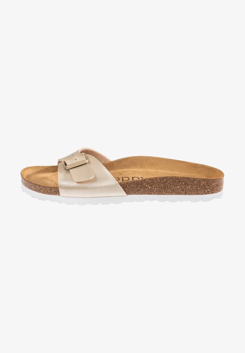 Beige sandal med en metallspänne, korkfotbädd och vit gummisula. Platt design med ett enda band över toppen.
