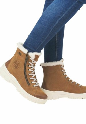 Bruine leren enkellaarzen met witte bontafwerking, voorzien van een zijrits, witte veters en een dikke witte zool. Ideaal voor casual gebruik.