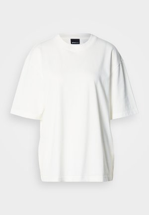 Balta, laisvo stiliaus, medvilninė marškinėliai, turinti apvalų iškirptę ir trumpas rankoves. Lygus paviršius su nevaržančiu siluetu.