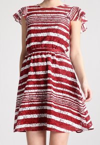 Robe en dentelle rayée rouge et blanche avec manches courtes à volants, taille cintrée et jupe évasée, présentant un motif floral en dentelle.