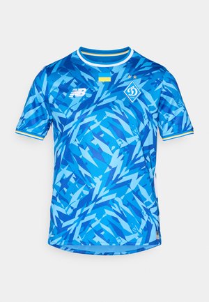 Mėlyna futbolo marškinė, turinti abstraktų geometrinį raštą įvairių atspalvių mėlynos spalvos. Apima apvalią apykaklę ir geltonus akcentus.