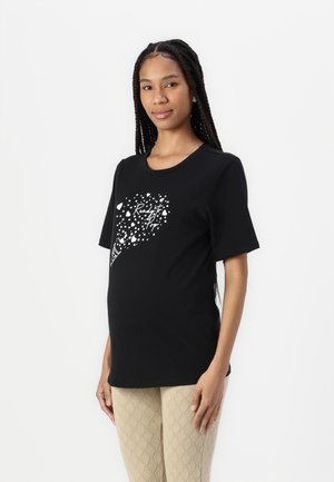 Black T-shirt with a round neckline, short sleeves, featuring a white graphic design of scattered hearts and text. Soft cotton material.