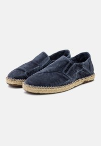 Scarpe slip-on in tela blu navy con pannelli laterali elastici, suole avvolte in juta e superficie liscia. Punta arrotondata e minima decorazione con cuciture.