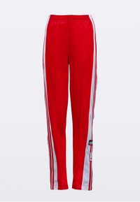 Punaiset urheiluhousut, joissa valkoiset sivupaneelit ja raidat, joustava vyötärönauhka sekä Adidas-logolla varustettu merkki vasemman nilkan läheisyydessä.