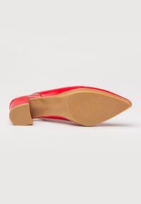 Zapato de tacón alto de cuero rojo con diseño de punta afilada. Presenta un acabado liso y una suela de goma texturizada. Talla 38 indicada en la suela.