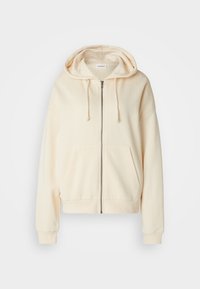 Sudadera con cremallera completa de color crema, con bolsillos frontales, capucha con cordón y puños y bajo acanalados sobre un fondo blanco.