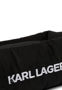 Must mustriga, millel on tekstuuriga kangas, külgedel valge tikand "KARL LAGERFELD" logoga, ristküliku kuju, nähtamatut riistvara pole.