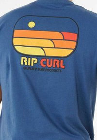 Blaues Baumwoll-T-Shirt mit einem bunten Retro-Design aus Streifen und einer Sonne auf der Rückseite, mit dem Text "RIP CURL" darunter.
