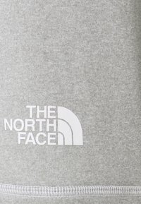 Szara bluza z miękkiego materiału z białym logo z zakrzywionymi akcentami, na którym widnieje pogrubiony napis "THE NORTH FACE".