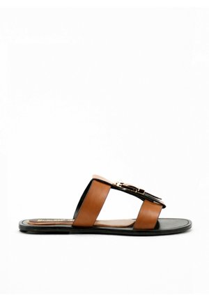 Sandalia plana negra con dos anchas correas de cuero marrón y un detalle metálico de hebilla en la parte superior.