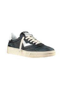 Sneaker in pelle nera con una striscia bianca accentuata, lacci color crema e una suola bianca testurizzata. Presenta un logo sulla linguetta.