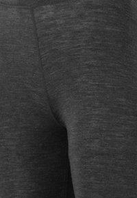 Leggings sportivi grigio scuro realizzati in tessuto a trama, con una texture liscia e un design aderente che si adatta al corpo.