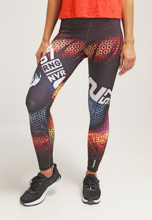 Leggings noirs avec un design coloré et à motifs présentant des rouges, des oranges et des bleus ; ornés de texte et de logos. Tissu texturé et extensible.