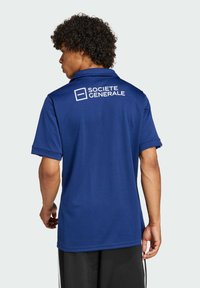 Mørkeblå polo t-shirt lavet af åndbart stof, med krave og korte ærmer, og med "Société Générale" logoet trykt på ryggen.