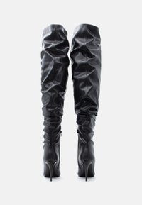 Botas pretas até à coxa feitas de couro sintético liso, com design franzido, bico fino e salto stiletto. Fecho lateral com zíper.