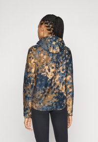 Hooded fleecejack met een blauw- en bruin tie-dye patroon, een gestructureerd oppervlak en een ontspannen pasvorm met een gebogen zoom.