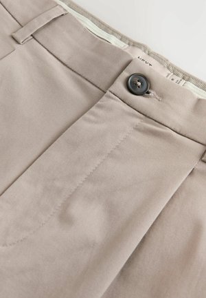 Beige Baumwollhosen mit einer glatten Textur, versehen mit einer Vordertasche, Knopfverschluss und dezenten Ziernähten.