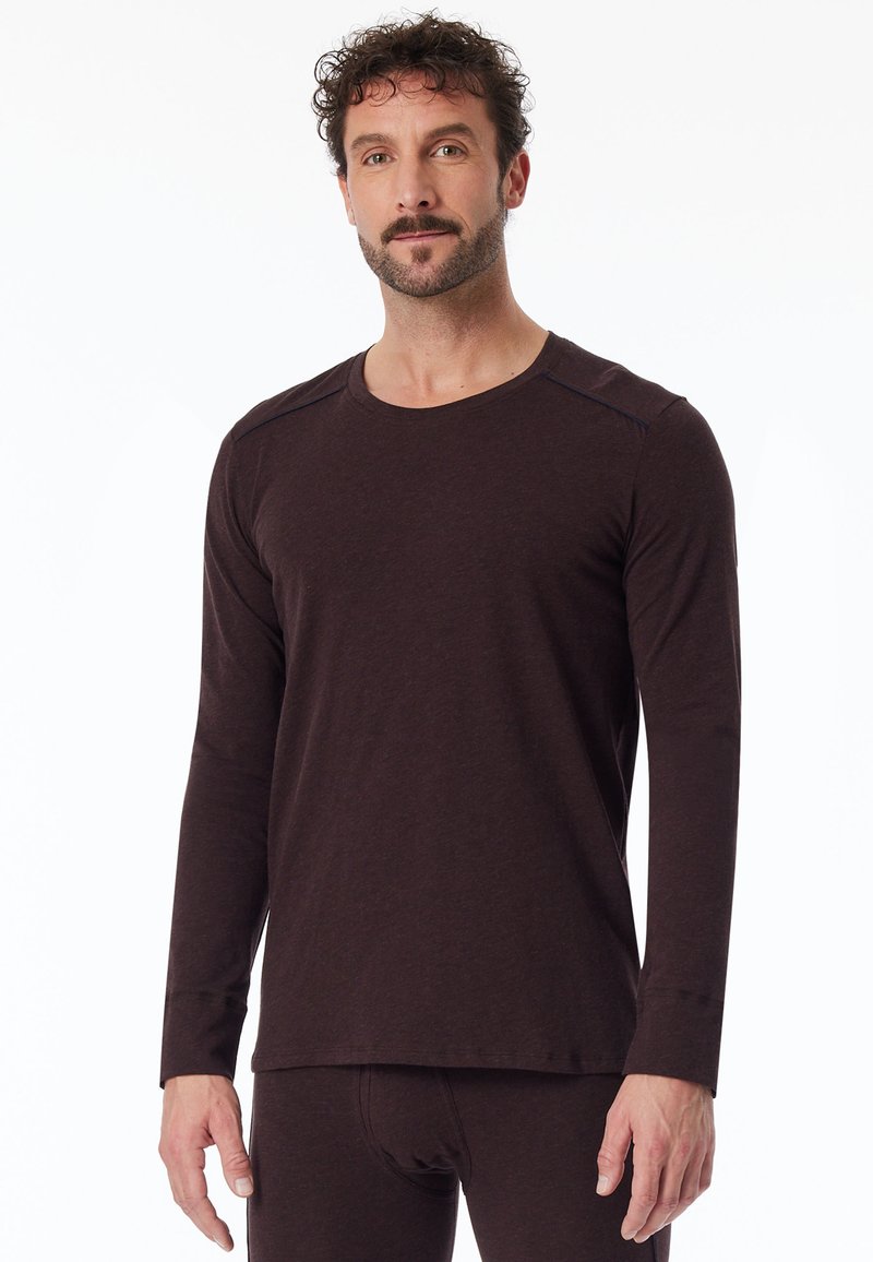 Ruskea pitkähihainen t-paita, joka on pehmeää materiaalia, pyöreällä kaula-aukolla ja hieman teksturoidulla pinnalla, joissa on kontrastivärit olkapäissä.