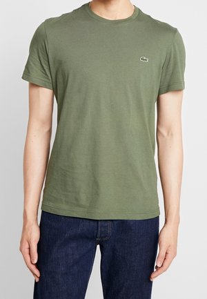 Olivgrünes Baumwoll-T-Shirt mit kurzen Ärmeln, Rundhalsausschnitt und gesticktem Logo auf der linken Brust. Glatte Textur, klassische Passform.