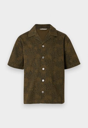 Īsām piedurknēm krekls olīvu zaļā krāsā ar teksturētu, dzīvnieku iedvesmotu rakstu. Tam ir asā apkakle un pogas priekšpusē, un tas ir brīvi pieguļošs.