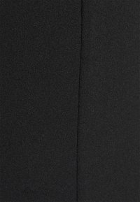 Tecido preto, textura suave, material de peso médio, com um detalhe de costura vertical. A aparência geral é sólida e sem padrões.