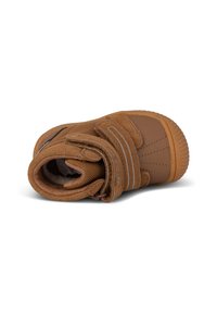 Botín de tobillo marrón de ante con un acabado texturizado, correa de velcro y suela de goma. Interior acolchado para mayor comodidad; incluye detalle del logo en el lateral.