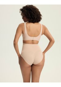 Naga biustonosz i majtki z wysokim stanem wykonane z gładkiego materiału, z regulowanymi ramiączkami, zapięciem na haczyk i oczko oraz bezszwowym wykończeniem.