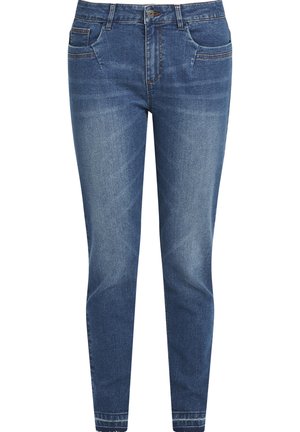 Jean en denim dans un bleu moyen avec une coupe slim, comportant cinq poches, des coutures contrastées et une texture lisse.