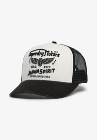 Casquette de baseball avec devant blanc et maille noire, aigle brodé et texte "Superdry Motors Japan Spirit Established 1954" sur le panneau avant.