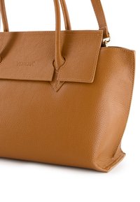 Brun struktureret læderhåndtaske med dobbelte håndtag, en flaplukning og en geometrisk form. Har diskret branding på fronten.