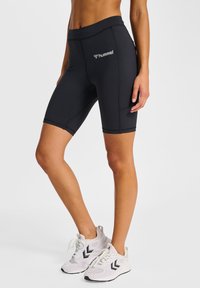 Højttaljede sorte cykelshorts med sømløst design og Hummel-logo. Blødt, elastisk stof med syningsdetaljer.