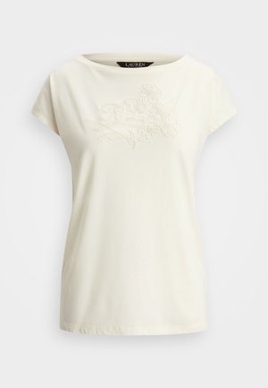 Kreem värvi lühikeste varrukatega T-särk, millel on rindkeres pehme tikandiga lillemuster. Valmistatud pehmest puuvillast, ümmarguse kaelusega.