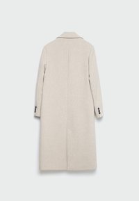 Cappotto lungo beige in tessuto testurizzato, con rever a punta, maniche lunghe e tre bottoni neri su ciascuna manica. Dettaglio con spacco centrale sul retro.