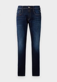 Tumed sinised denim püksid, kitsas istuvus, kontrastsete õmblustega, nööbiga sulgemine ja viie tasku disain. Sile tekstuur, minimaalne kulumine.