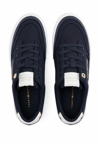 Sneakers in canvas blu navy con suole in gomma bianche, punta tonda, design con lacci e branding dorato sulla linguetta e sul lato. Parte superiore in tessuto testurizzato.