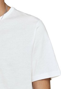 Witte katoenen T-shirt met korte mouwen, een ronde halslijn en een gladde textuur, met een minimalistisch ontwerp en schone randen.