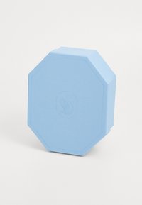 Envase octagonal de color azul claro, hecho de un material texturizado; presenta un sutil logo en relieve de un cisne en su superficie.