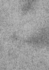 Nära bild av grå filt som visar en tät, fiberrik textur med varierande nyanser och mjuka, fluffiga ytdetaljer.