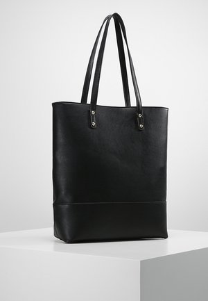 Sort læder tote taske med lange dobbelte håndtag, rektangulær form og minimalistisk design på en hvid piedestal mod en lys grå baggrund.