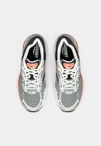 White and gray mesh running shoes with black accents, textured pattern, orange logo detail, and white laces on a light background.