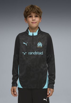 Schwarz-blaues Trainingsjacke-Top mit halbem Reißverschluss, Mustern und dem Puma-Logo. Zeigt ein Mannschaftswappen und Sponsorenschrift auf der Vorderseite.