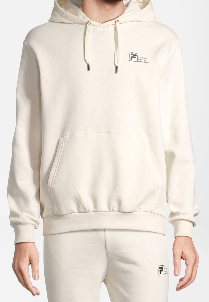 Kremowa bluza z kapturem wykonana z miękkiego materiału, z przednią kieszenią, kapturem ze sznurkiem i logo na lewej stronie klatki piersiowej.
