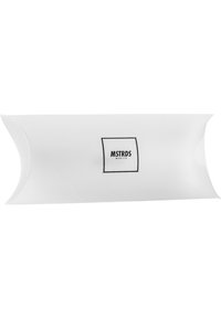 Weiße Pillow-Box-Verpackung mit abgerundeten Ecken, die ein schwarzes rechteckiges Etikett mit der Aufschrift "MSTRDS München" in fettem Text zeigt.