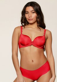 Rode beha en bijpassende slip gemaakt van gladde stof. De beha heeft kantdetails op de straps en een strikaccent in het midden.
