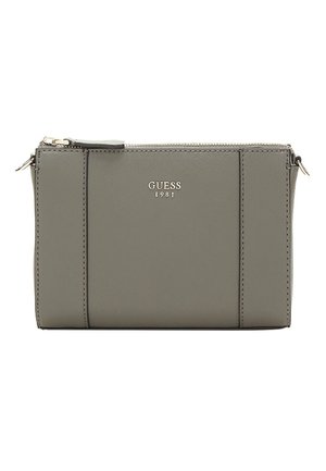 Pochette en tissu synthétique gris avec une fermeture éclair, présentant un design simple et un logo "GUESS 1981" en relief à l'avant.