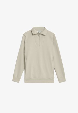 Beige svetr s dlouhým rukávem vyrobený z měkké látky, s půlzipovým límcem, dlouhými rukávy a volným střihem se rovnym lemem.