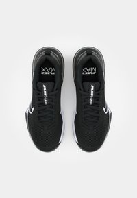 Ett par svarta Nike Air Max sneakers med vita logotyper och överdel av mesh, sedd uppifrån mot en vanlig vit bakgrund.